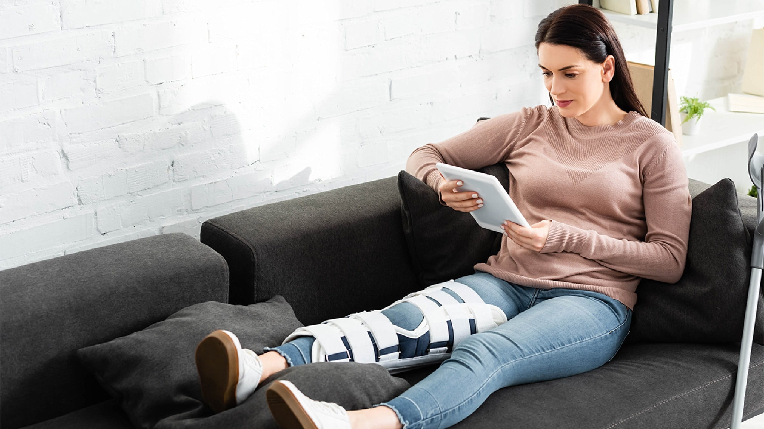 Vrouw consulteert de dienst Doctors Online van AXA via haar tablet.