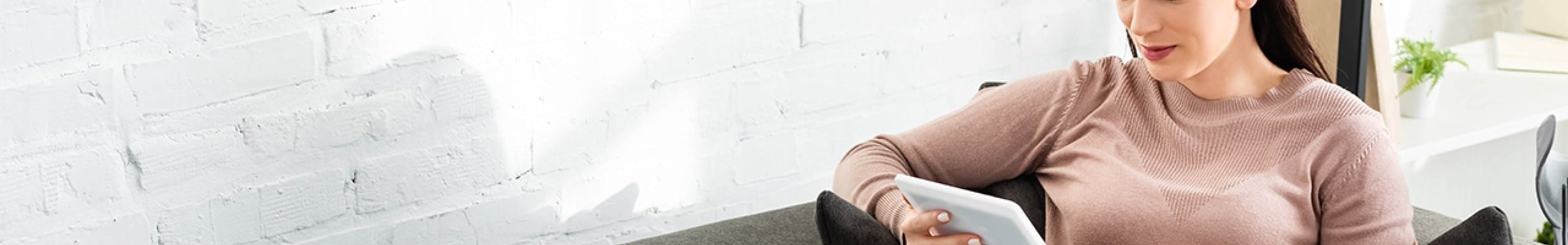 Vrouw consulteert de dienst Doctors Online van AXA via haar tablet.