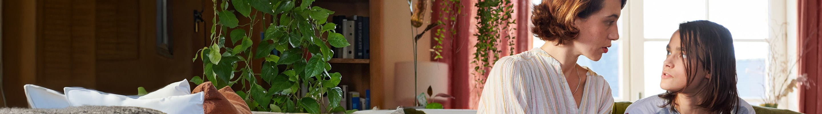 Een moeder troost haar kind dat slachtoffer is van pesten op school.