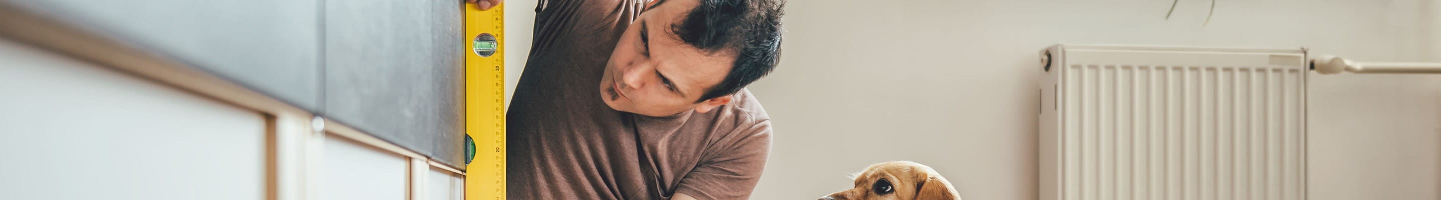 Homme qui rénove sa maison avec son chien à ses côtés