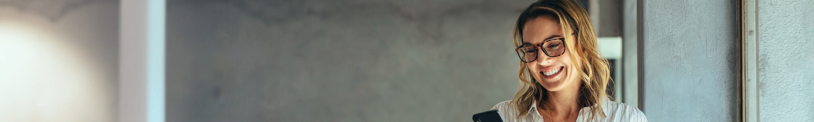 Indépendante consulte sur son téléphone les détails de son assurance revenu garanti.