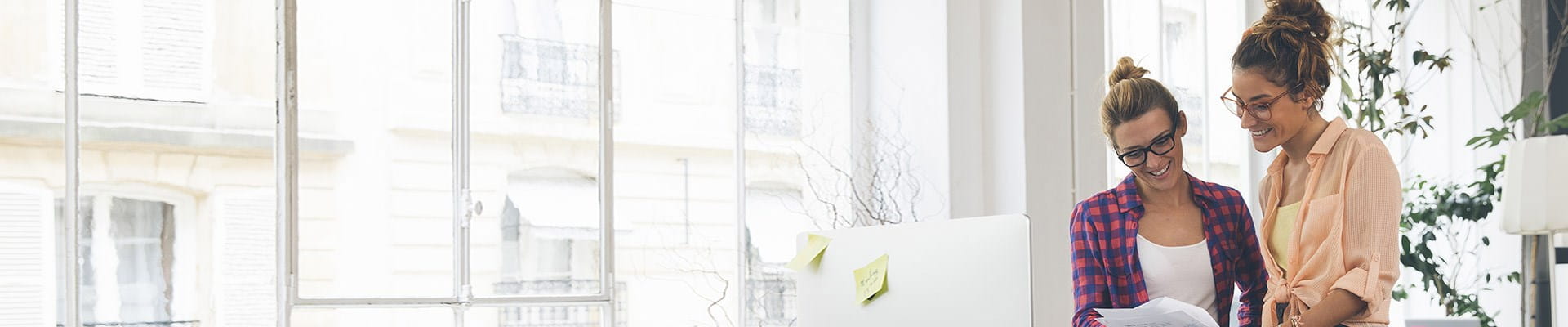 Twee vrouwen in een kantoor die de spaarformules voor een aanvullend pensioen voor startende zelfstandigen bekijken.