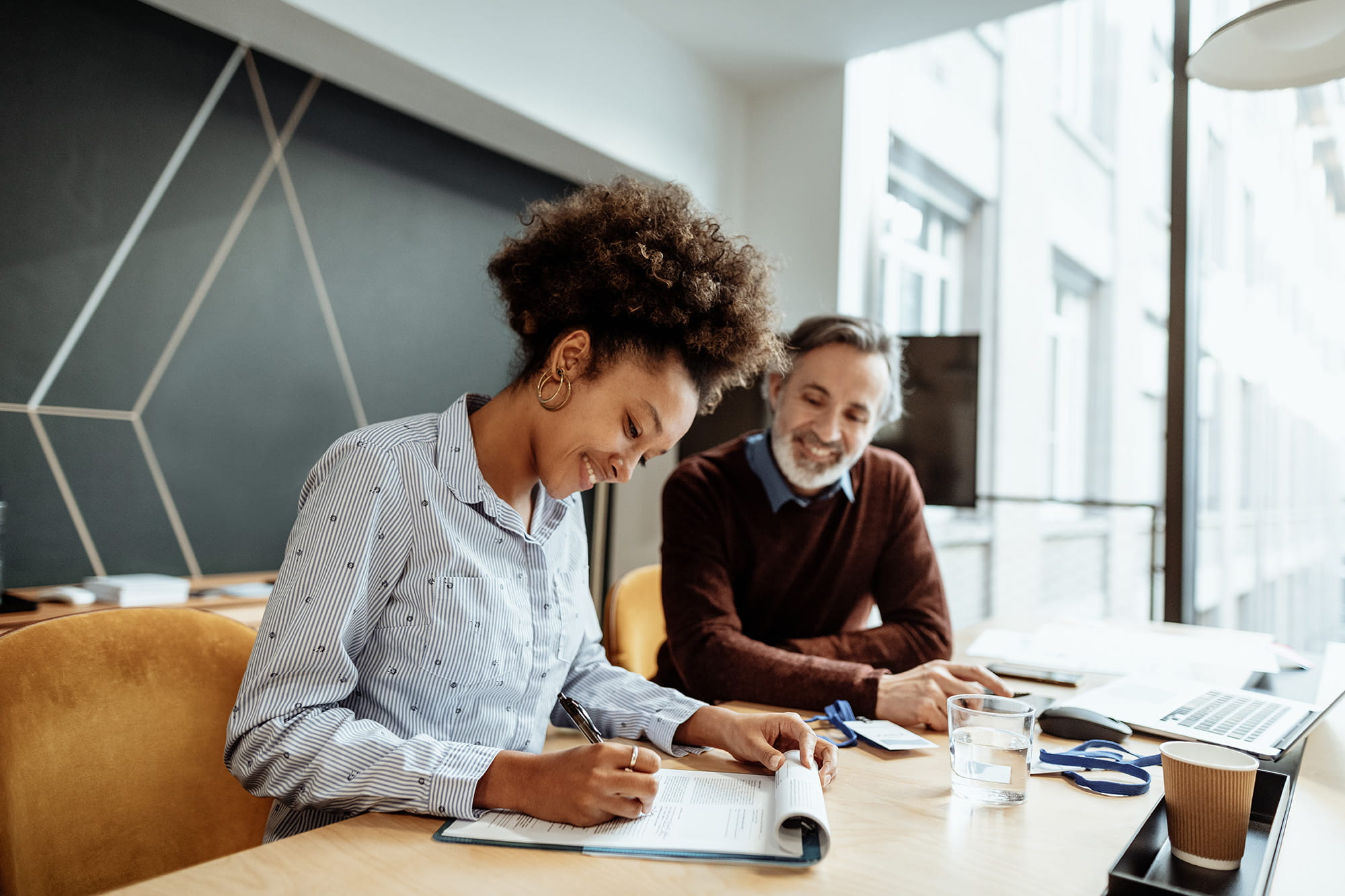 Een vrouw bespreekt met haar verzekeringstussenpersoon hoe ze de dekkingen van haar verzekeringscontract kan wijzigen. 