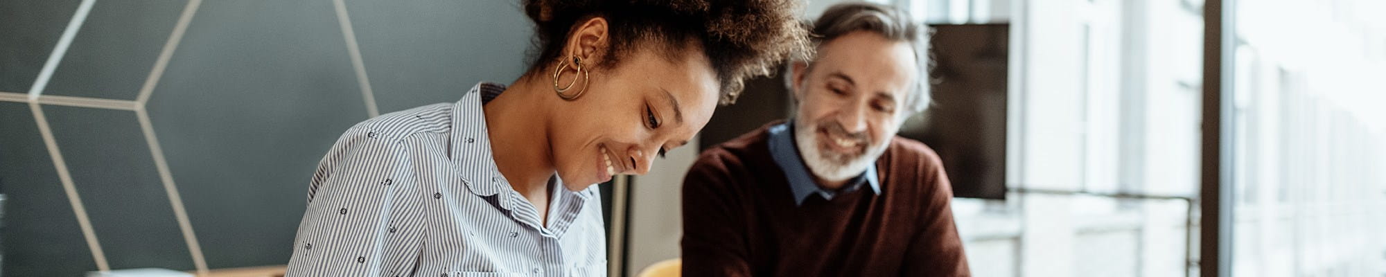 Une femme accompagnée de son intermédiaire en assurances pour changer de formule d’assurance concernant l’ajout ou la suppression d’une garantie à son contrat d’assurance