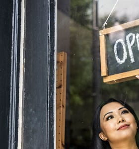 Femme ouvrant son entreprise, sereine car elle sait qu’elle a une bonne assurance incendie entreprise