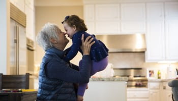 Een oudere vrouw speelt met haar kleindochter, die dankzij generation skipping kan profiteren van lagere successierechten.
