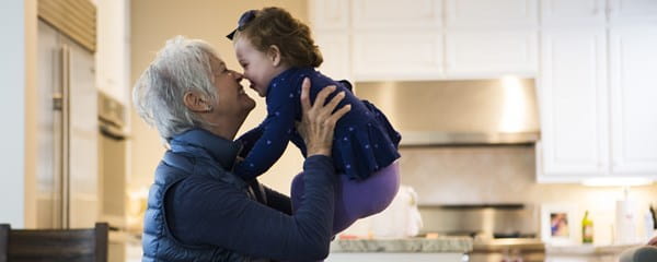 Een oudere vrouw speelt met haar kleindochter, die dankzij generation skipping kan profiteren van lagere successierechten.