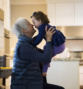 Een oudere vrouw speelt met haar kleindochter, die dankzij generation skipping kan profiteren van lagere successierechten.