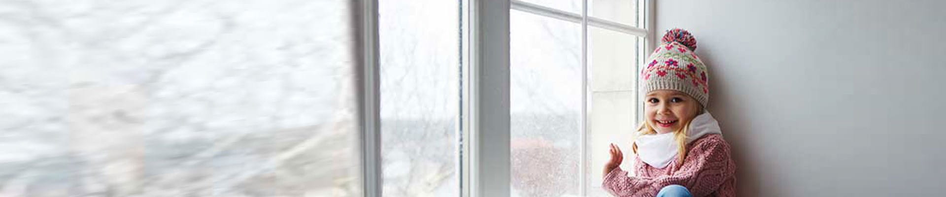 Kind met een muts in een huis dat beter geïsoleerd moet worden