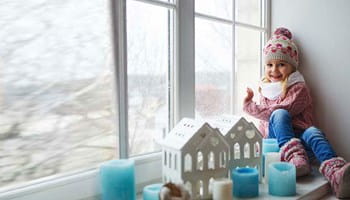 Enfant avec un bonnet qui a froid dans sa maison mal isolée