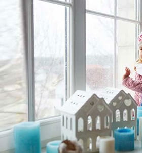 Enfant avec un bonnet qui a froid dans sa maison mal isolée