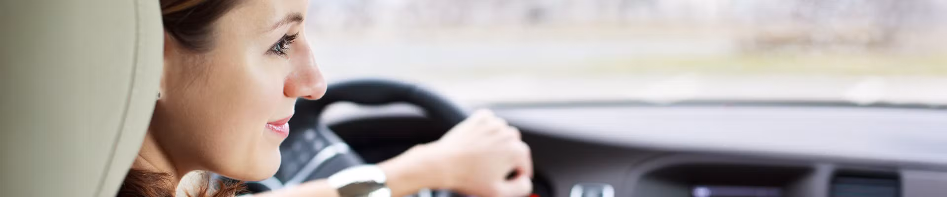 Une femme qui conduit tranquillement sa voiture, économisant du carburant.