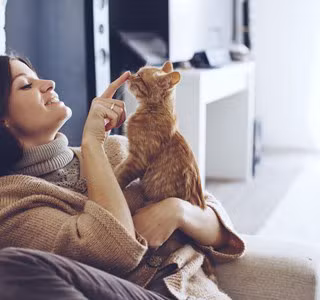 Vrouw speelt met haar kat na een verhuizing