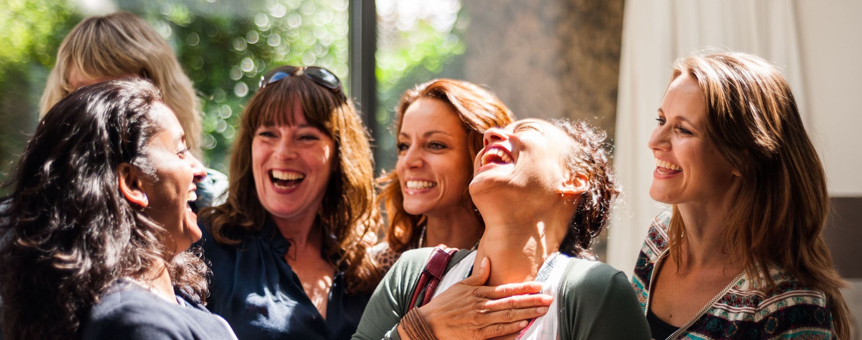 Un groupe de femmes issues de divers horizons partageant un moment de joie sans se laisser abattre par les violences faites aux femmes et les inégalités économiques persistantes 
