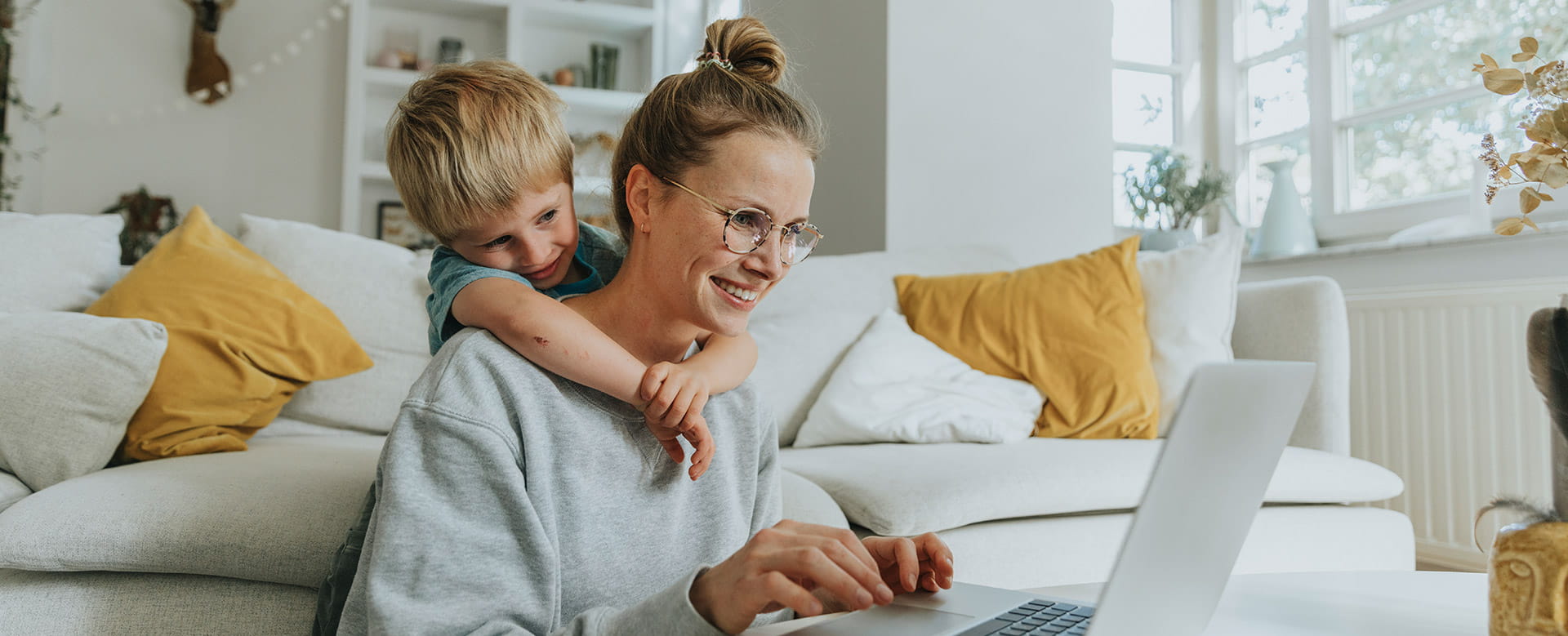Een moeder wint informatie in over ongevallen tijdens de werkuren, terwijl haar zoontje over haar schouder meekijkt. 