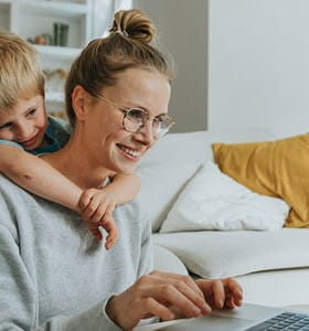 Een moeder wint informatie in over ongevallen tijdens de werkuren, terwijl haar zoontje over haar schouder meekijkt.