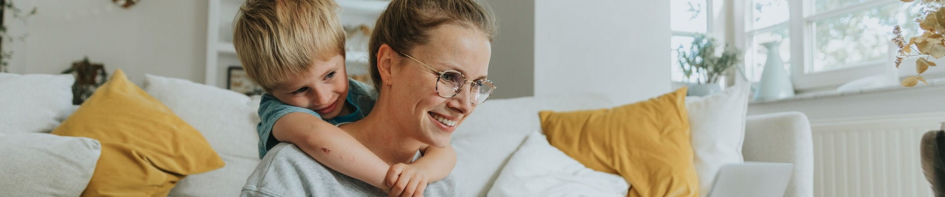 Een moeder wint informatie in over ongevallen tijdens de werkuren, terwijl haar zoontje over haar schouder meekijkt.