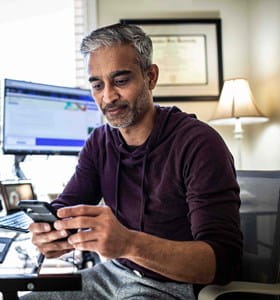 Homme qui utilise l’intelligence artificielle sur son ordinateur et téléphone