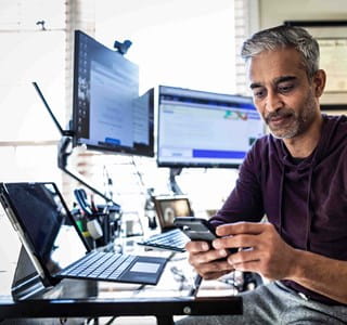 Man gebruikt artificiële intelligentie op zijn laptop en op zijn gsm.