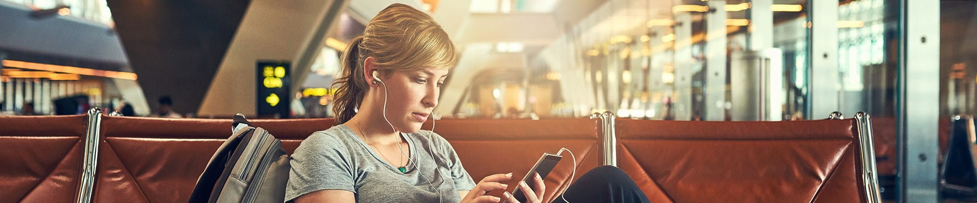 Vrouw moet wachten op de luchthaven omdat haar vlucht vertraging heeft.