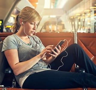 Une femme doit attendre à l'aéroport car son vol a été annulé.