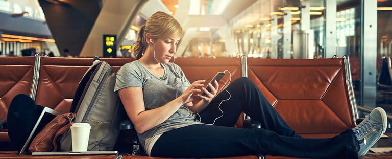 Une femme doit attendre à l'aéroport car son vol a été annulé.
