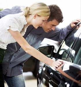 Couple qui regarde pour acheter une nouvelle voiture.