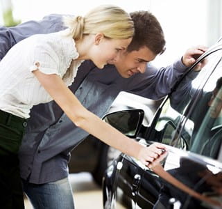 Couple qui regarde pour acheter une nouvelle voiture.