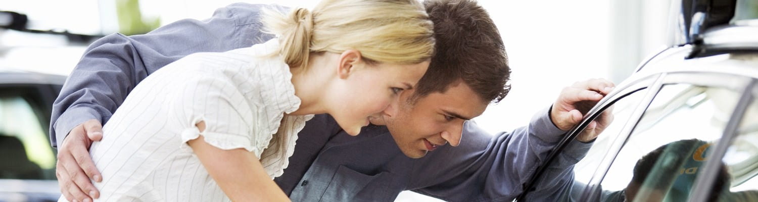 Couple qui regarde pour acheter une nouvelle voiture.