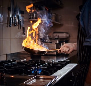 Poêle en feu dans une cuisine, qui crée un risque d’incendie domestique.
