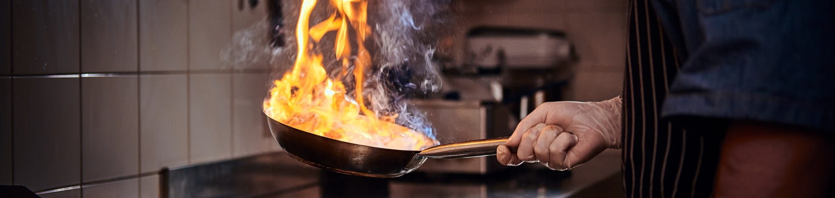 Poêle en feu dans une cuisine, qui crée un risque d’incendie domestique.