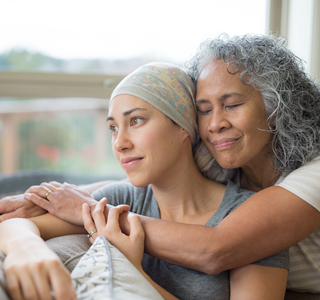 Femme d’âge mûr réconfortant une autre femme atteinte d’un cancer.