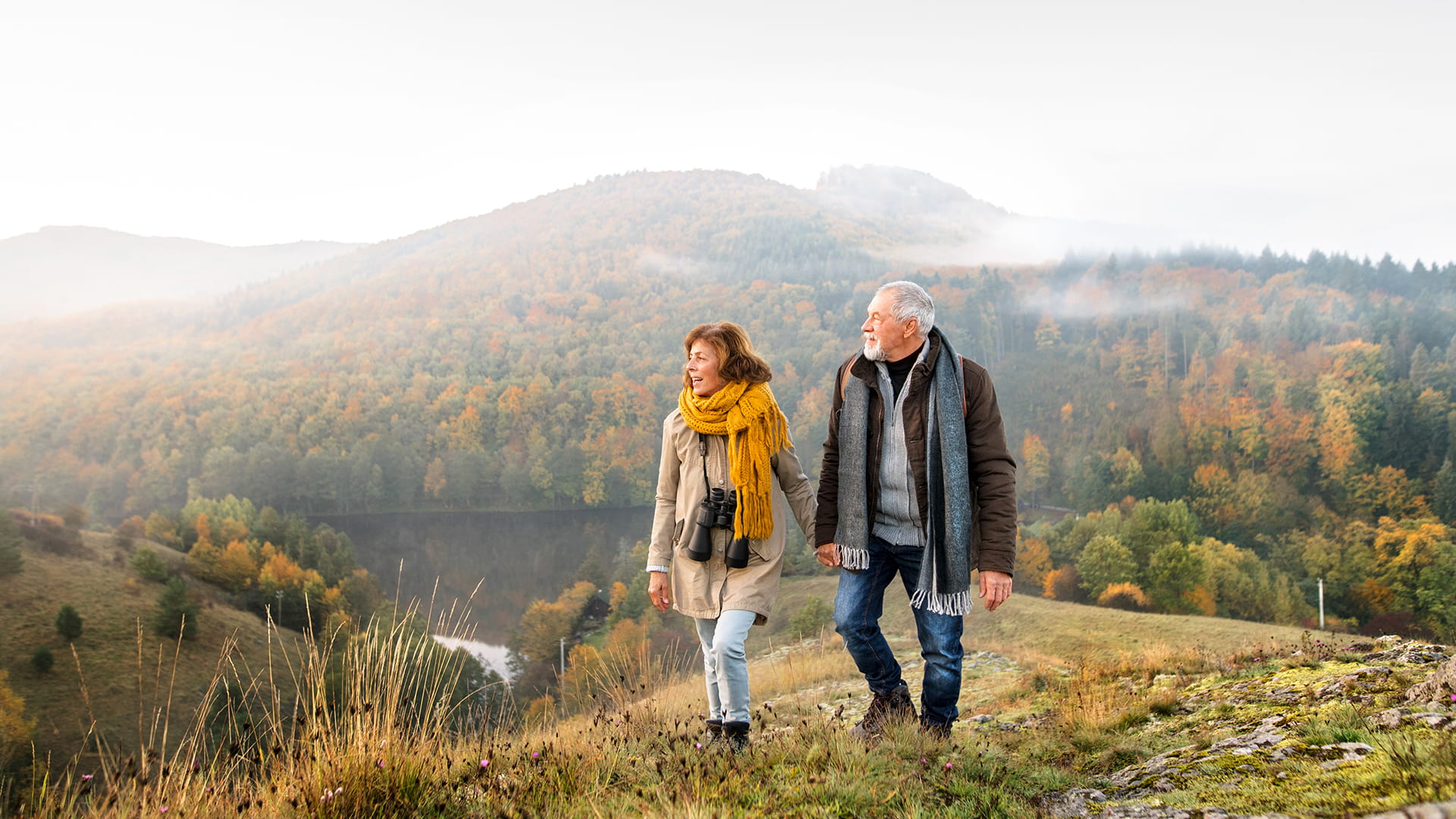 Een koppel vijftigers wandelt in de Ardennen. Dik ingeduffeld en tegen de achtergrond van een bos met herfstkleuren denken ze eraan om hun langetermijnsparen fiscaal te optimaliseren.