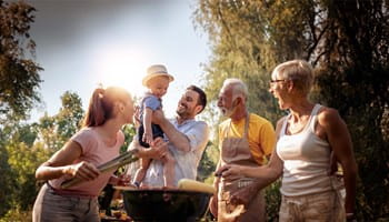 Familie met grootouders, kinderen en kleinkinderen geniet samen van een gezellige barbecue.