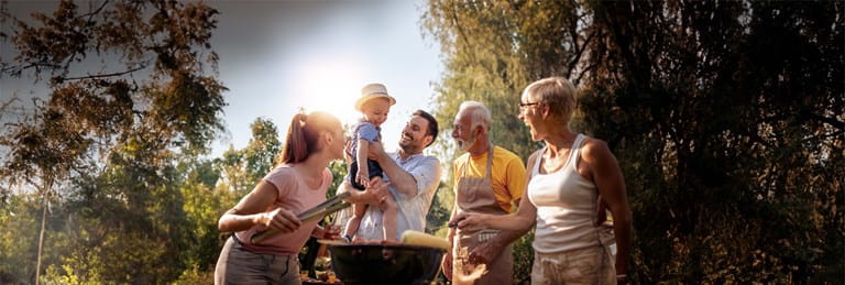 Familie met grootouders, kinderen en kleinkinderen geniet samen van een gezellige barbecue.