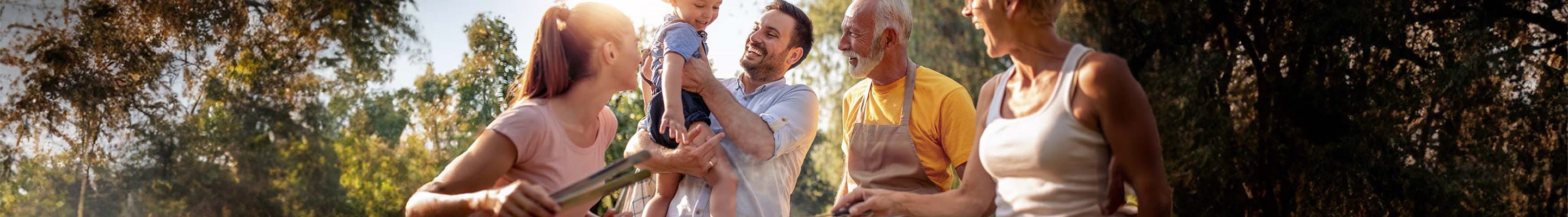 Une famille avec grands-parents, enfants et petits-enfants autour d'un barbecue convivial