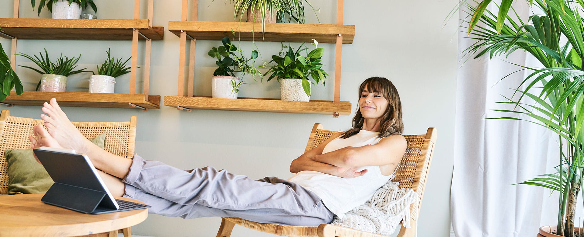 Vrouw zit ontspannen in haar huis, gerustgesteld door haar woonverzekering. 