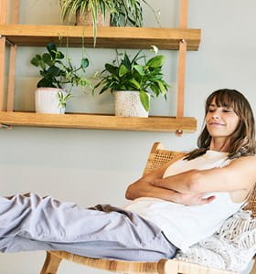 Femme confortablement installée dans sa maison, rassurée par son assurance habitation.