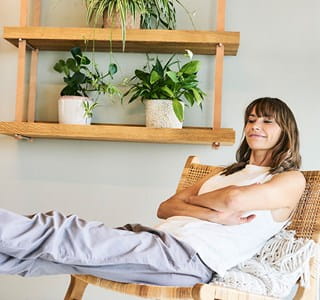 Femme confortablement installée dans sa maison, rassurée par son assurance habitation.