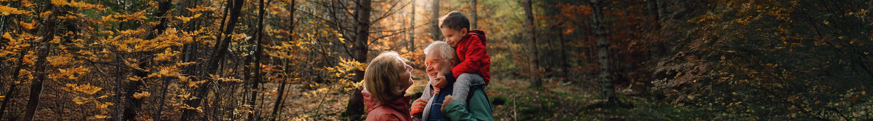 Grootvader, dochter en kleindochter wandelen in het bos en voeren een gesprek over de levensverzekering als successieplanningsinstrument.