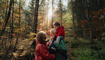 Un grand-père, sa fille et sa petite-fille se promènent dans la forêt et discutent de l’assurance-vie comme instrument de planification successorale.