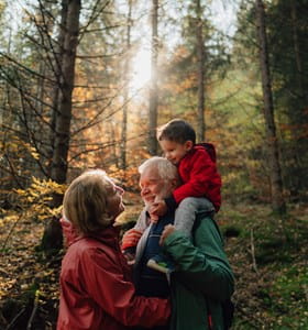 Un grand-père, sa fille et sa petite-fille se promènent dans la forêt et discutent de l’assurance-vie comme instrument de planification successorale.