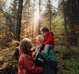 Un grand-père, sa fille et sa petite-fille se promènent dans la forêt et discutent de l’assurance-vie comme instrument de planification successorale.