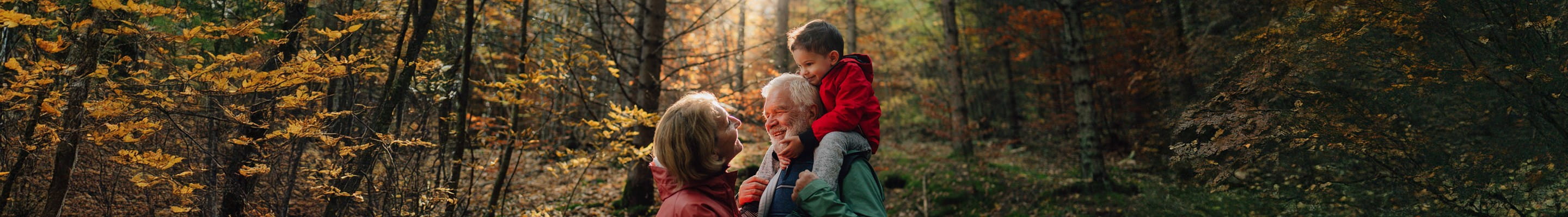 Grootvader, dochter en kleindochter wandelen in het bos en voeren een gesprek over de levensverzekering als successieplanningsinstrument.