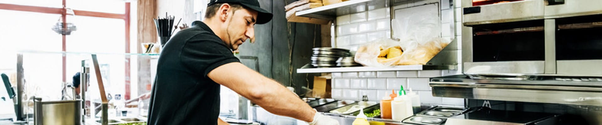 Een horecapersoneelslid bereidt en serveert gerechten volgens de FAVV- en HACCP-richtlijnen.