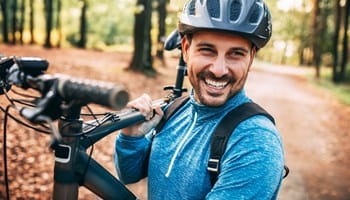 Homme portant un casque de vélo, qui se rend à vélo au travail et bénéficie d’une réduction sur son assurance Auto.