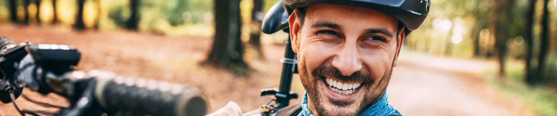 Homme portant un casque de vélo, qui se rend à vélo au travail et bénéficie d’une réduction sur son assurance Auto.