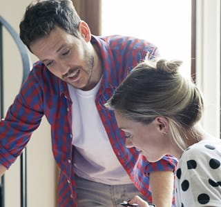 Koppel bekijkt renovatieplannen voor hun huis.