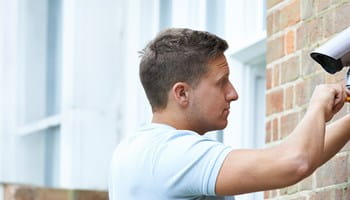 Homme installant une caméra comme protection contre le vol