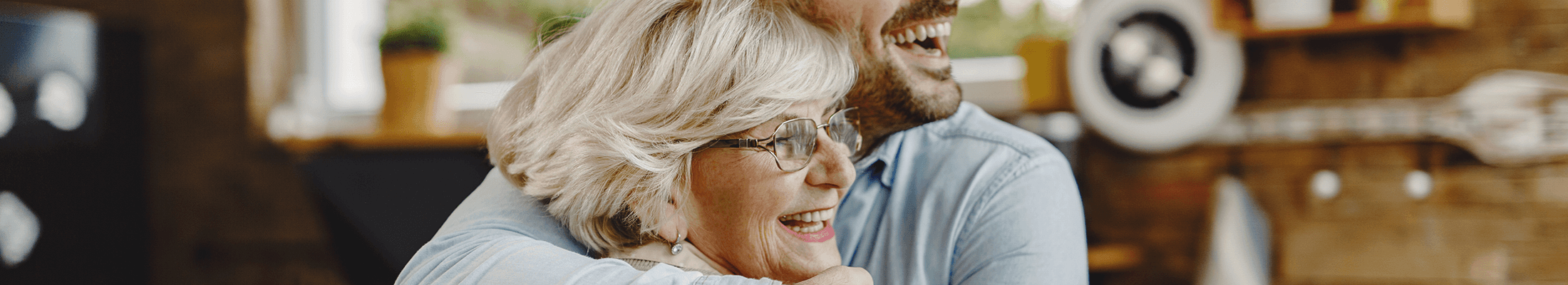 Une mère souriante enlace son fils dans la cuisine après avoir discuté d’investissement en cycle de vie en branche 23 à la table.